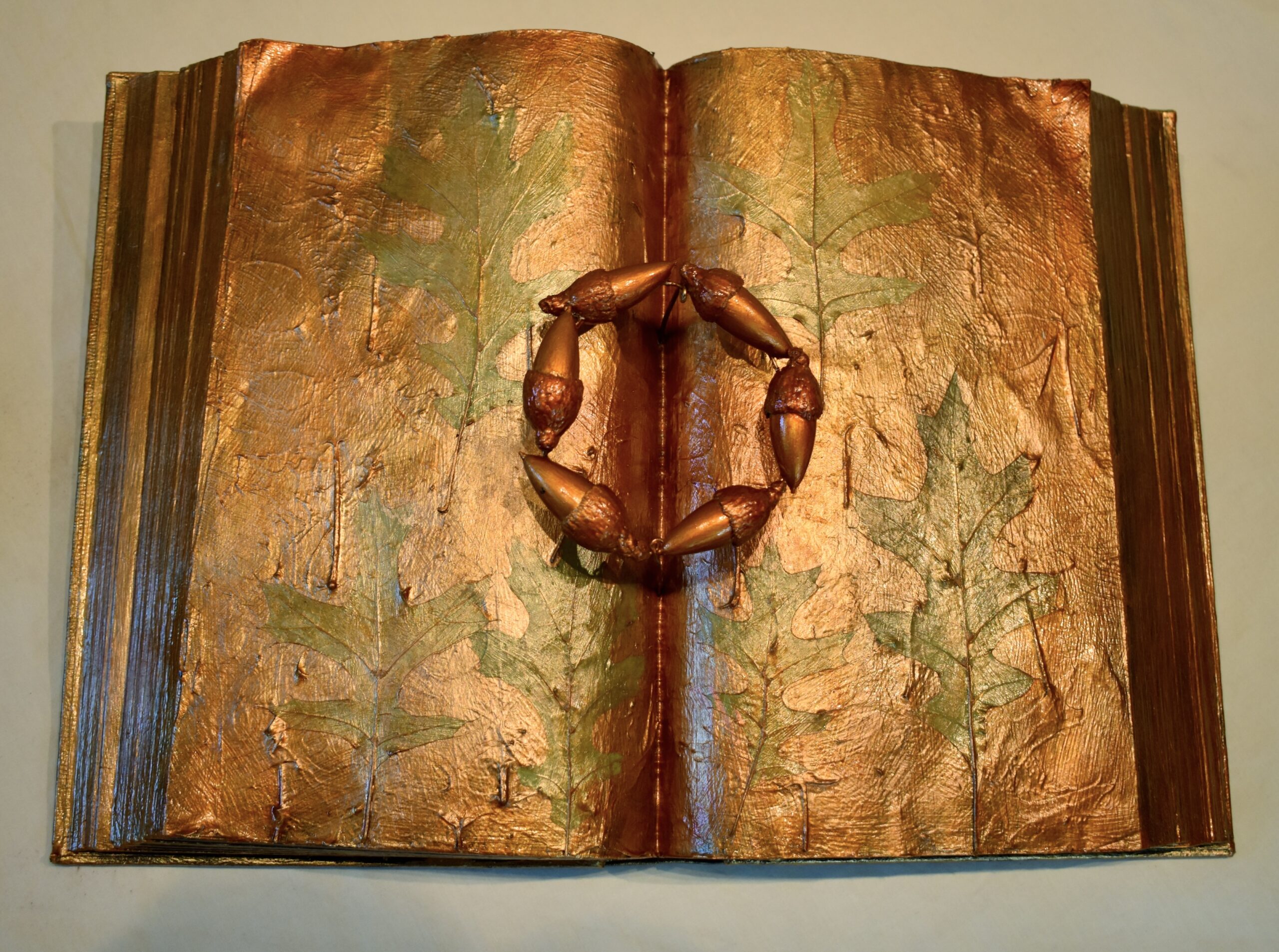 This altered book features oak acorns and leaves, Sudden Oak Death pathogens, drought, and wildfires are decimating Oak Trees in California.